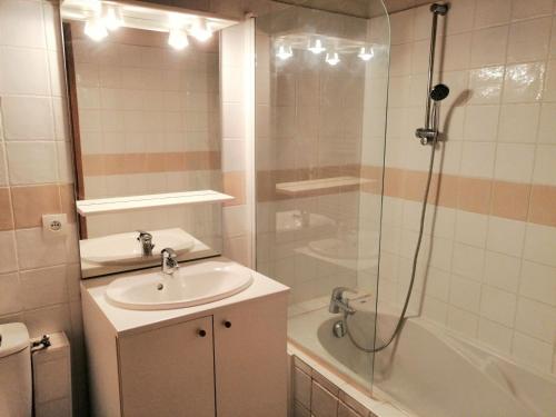 uma casa de banho com um lavatório, um chuveiro e uma banheira em Appartement Morillon 1100, 4 pièces, 8 personnes - FR-1-412-73 em Morillon