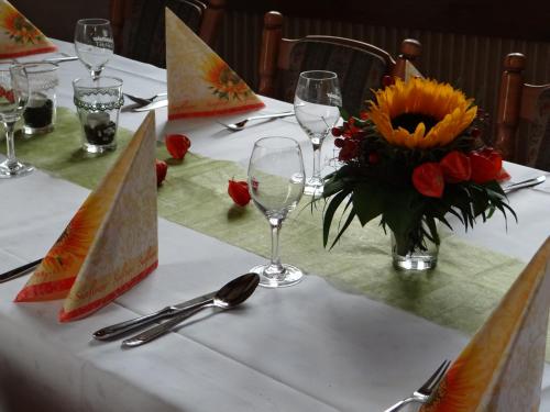 a table with glasses and a vase of flowers on it at Gasthaus Post in Goldbach