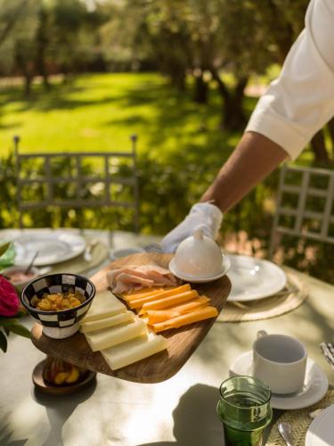 a person holding a plate of cheese and other foods at CASA ABRACADABRA in Marrakech