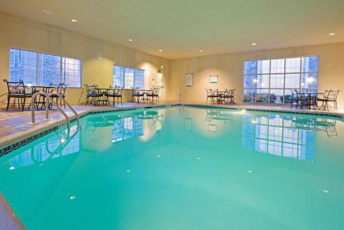 a large swimming pool in a hotel with tables and chairs at Staybridge Suites-Philadelphia/Mount Laurel by IHG in Mount Laurel