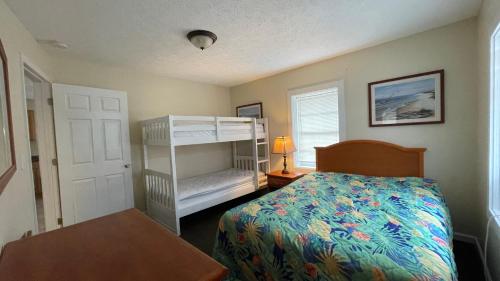 a bedroom with a bed and a bunk bed at Cottages Christian Retreat in Panama City Beach