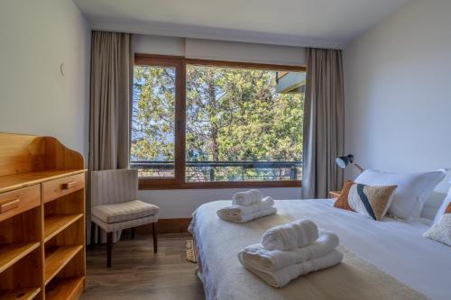 una camera da letto con un letto e due asciugamani di Peñon de Arelauquen Suites del Lago Bariloche Lenga 1C a San Carlos de Bariloche