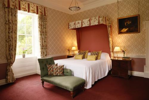 a bedroom with a bed and a chair and a window at Coopershill House in Riverstown