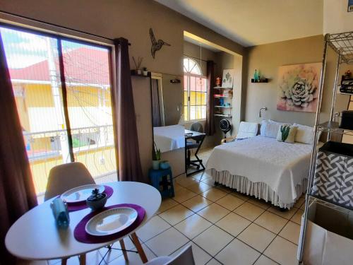 um quarto com uma cama e uma mesa e um quarto com uma mesa; em Cómodo Apartamento privado em Tegucigalpa
