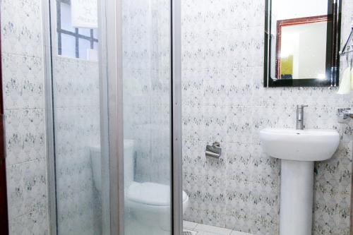 La salle de bains est pourvue d'une douche, d'un lavabo et de toilettes. dans l'établissement The Gem - Kiambu road 1 bedroom, à Kiambu