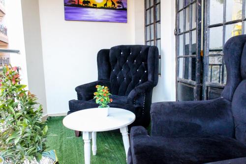 two chairs and a table in a room at The Gem - Kiambu road 1 bedroom in Kiambu