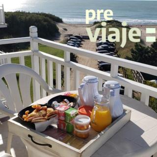 a tray of food and drinks on a table on a chair at Costa Carilo Apart de Mar By HS in Carilo