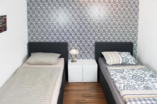 two beds in a small room with a wall at Ferienwohnung in Isenbüttel in Isenbüttel