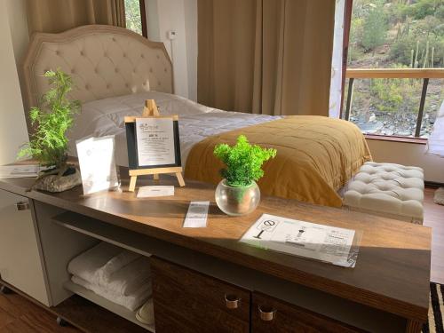 a table with a bed in a room at BORDEMAIPO LODGE in San José de Maipo