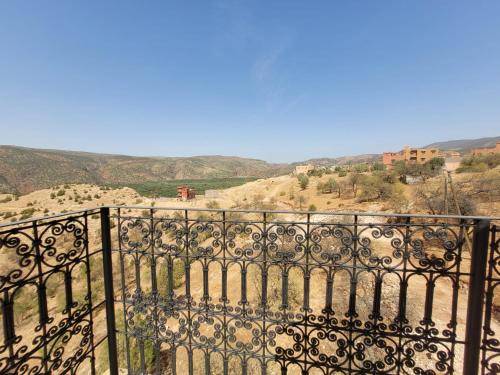 an iron fence with a view of the mountains at Riad Heermans in Ouzoud
