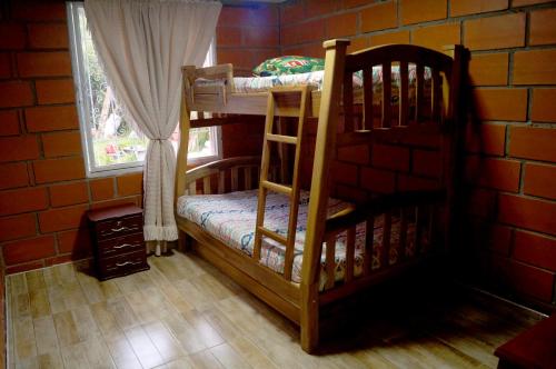Pokój z 2 łóżkami piętrowymi w ceglanej ścianie w obiekcie Casa Campestre la Guacamaya w mieście San Félix