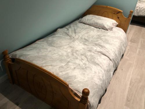 a bed with a wooden frame with a pillow on it at The Little Hexthorpe house in Doncaster