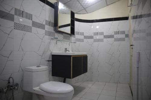a bathroom with a toilet and a sink at Valhalla Resort Kumrat in Tāl