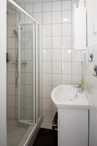 a white bathroom with a sink and a shower at JóKissHely Vendégház in Erdőbénye