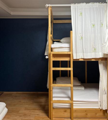 two bunk beds in a room with a blue wall at Jo Eun Jip Guesthouse in Mokpo