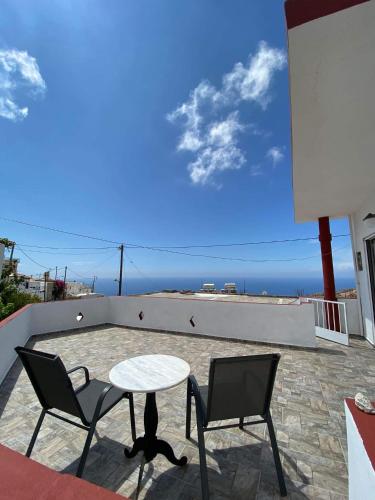 una mesa y sillas en un patio con vistas al océano en GIANNIS-KLEOPATRA HOUSE 1 en Kerames