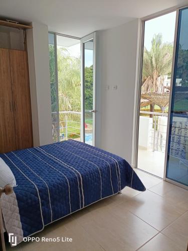 una camera da letto con un letto con un piumone blu di Casa vacacional condominio bambú a Carmen de Apicalá