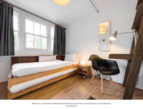 sypialnia z łóżkiem i krzesłem w obiekcie Traditional Victorian 2 bed in cobbled street + mod cons - Full home w Londynie