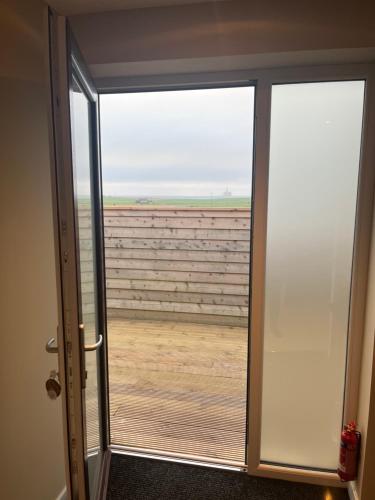 an open door with a view of a field at Loanside Lodge, Self-Catering, Holm, Orkney. in Saint Marys