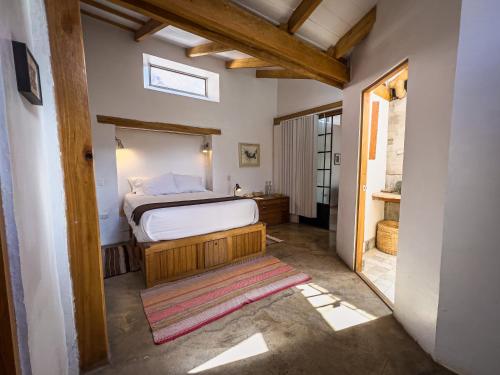 a bedroom with a bed in a room with a window at El Albergue Ollantaytambo in Ollantaytambo