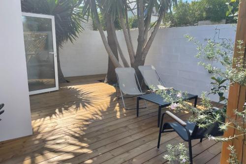 une terrasse avec 2 chaises, une table et un arbre dans l'établissement MAISON Rue de Port Haliguen CENTRE VILLE, à Quiberon