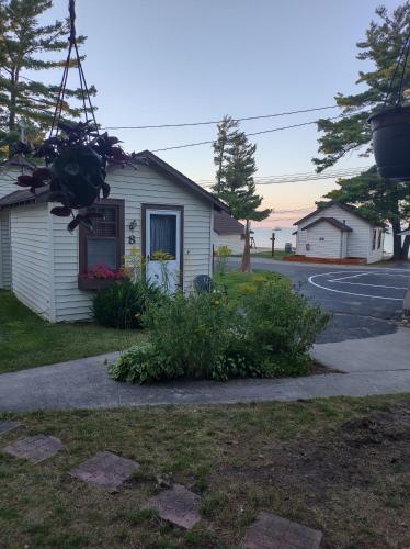 a house on a street with a tree at Beach House Lakeside Cottages in Mackinaw City