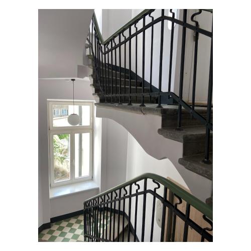 a staircase with black railings and a window at Lwowska Studios - STAYINWARSAW in Warsaw