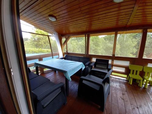 un porche cubierto con mesa y sillas en Dom NARIE na Mazurach nad Jeziorem Narie, en Bogaczewo