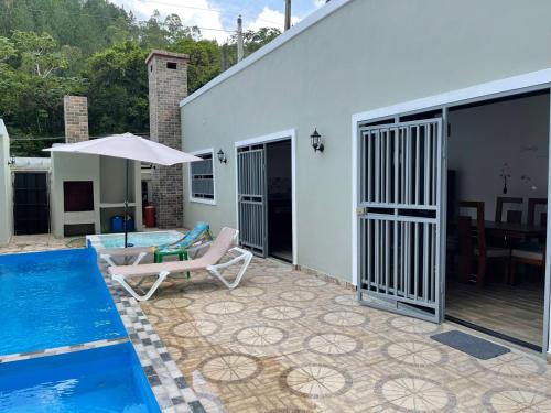 a patio with a swimming pool and a house at Villa Flor 2022 in Los Plátanos