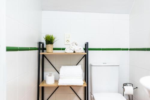 łazienka z półką z ręcznikami i toaletą w obiekcie Home4u Casa del Tesoro I w Grenadzie