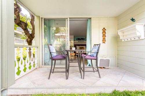 a patio with a table and chairs on a porch at Kona Islander Inn - Prime Downtown Location with Hot Tub, Pool & Beach in Kailua-Kona