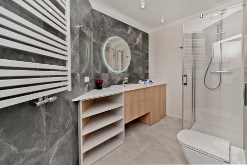 a bathroom with a toilet and a sink and a shower at BlueApart Apartamenty Na Klifie in Władysławowo