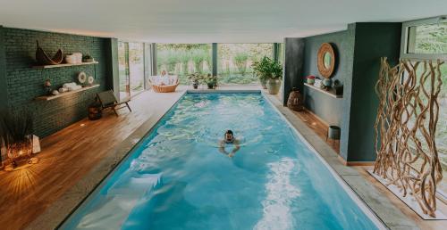 a woman in a swimming pool in a house at Villa Geva in Montignies-le-Tilleul