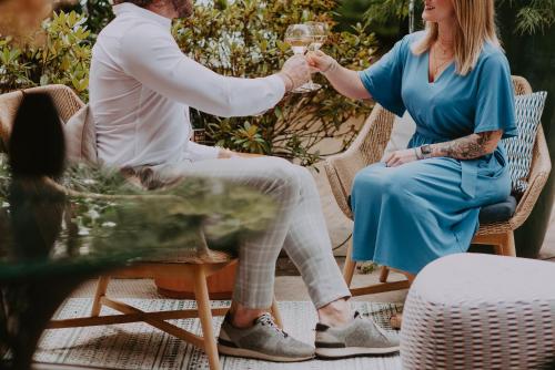 a man and a woman sitting in wicker chairs drinking wine at Villa Geva in Montignies-le-Tilleul
