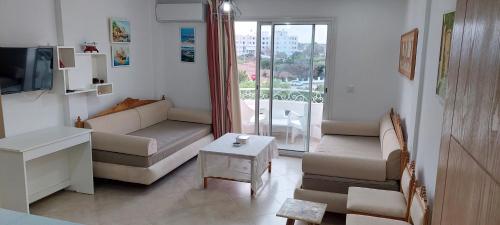 a living room with a couch and a tv at Apartment in LTI Mahdia Beach Hotel in Mahdia