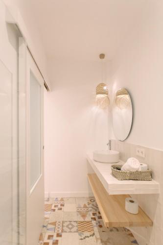 a white bathroom with a sink and a mirror at La Vila Hort by Seaward Suites in Villajoyosa