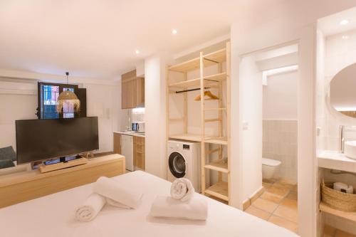 La Vila Hort by Seaward Suites في فايلاجويوسا: غرفة بسرير وتلفزيون وحمام