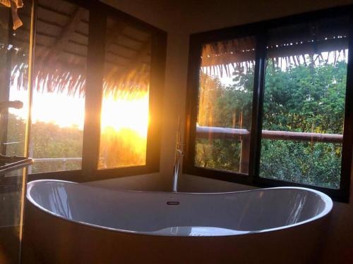 a bath tub in a bathroom with two windows at Cascadas Corcovado - luxury villa in Charcos