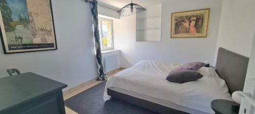 sypialnia z łóżkiem z poduszką w obiekcie Grande Maison dans le Bourg de Nevez + jardin w mieście Névez