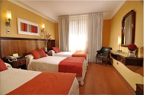 Habitación de hotel con 2 camas y ventana en Hotel Gran Palace, en Santiago