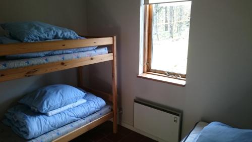 a bedroom with two bunk beds and a window at Daemningen at Gammel Rye in Ry