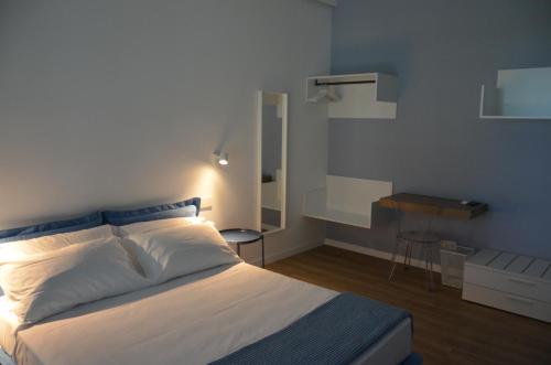 1 dormitorio con cama blanca y mesa en La Cicada en Camerano