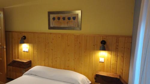 um quarto com duas luzes numa parede de madeira em La Casa Rural de Alicia em Bustares