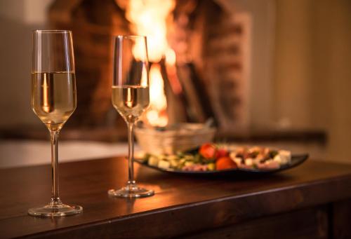 two glasses of wine on a table with a plate of food at Guayaba Inn Boutique Hotel in San Cristóbal de Las Casas
