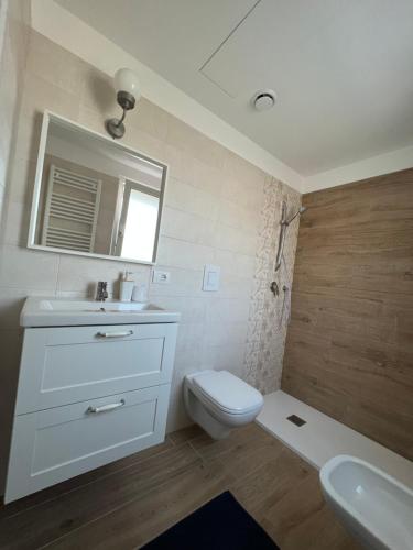 a bathroom with a toilet and a sink and a mirror at The Plus #3 HOWME in Bari