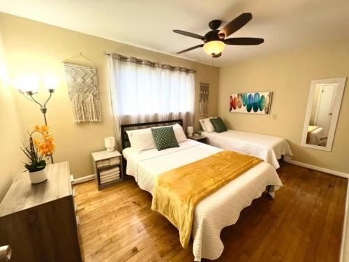 a bedroom with two beds and a ceiling fan at *Comfortable Townhome * King Beds * Long Term* in Cary