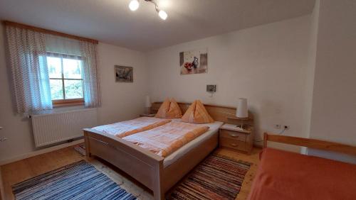 um quarto com uma cama, uma secretária e uma janela em Spulhof em Abtenau