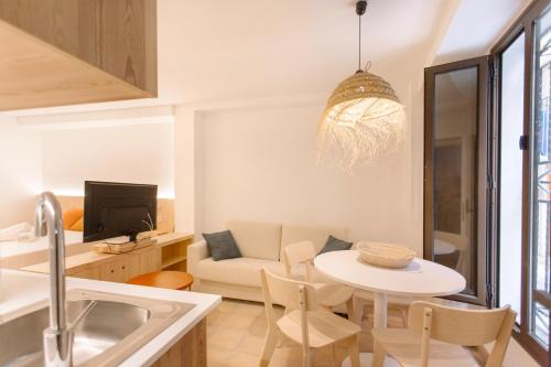 La Vila Hort by Seaward Suites في فايلاجويوسا: غرفة معيشة مع طاولة وأريكة