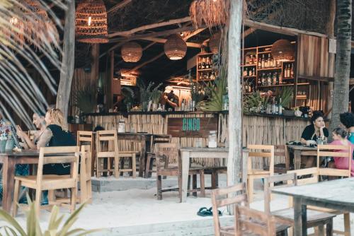 a group of people sitting at tables in a restaurant at Cinco Tulum in Tulum