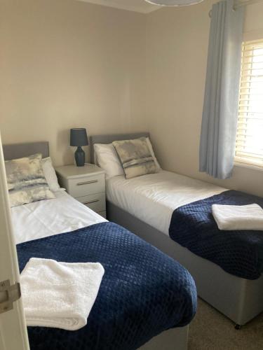 a bedroom with two beds and a window at Augusta lodge in Wisbech